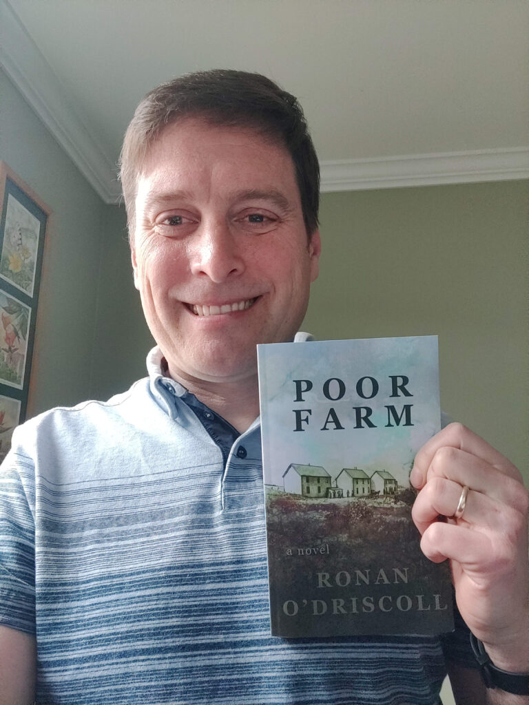 Author holding copy of Poor Farm